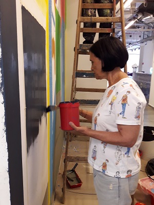 מעצבת אביבית מדינה עובדת על ציור קיר במרכז הבנייה הישראלי