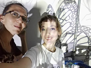 אנה קוגן וצוות אנסטסיה חובינה מול ציור קיר של דרקון בחנות אומנות ארטיסט 18